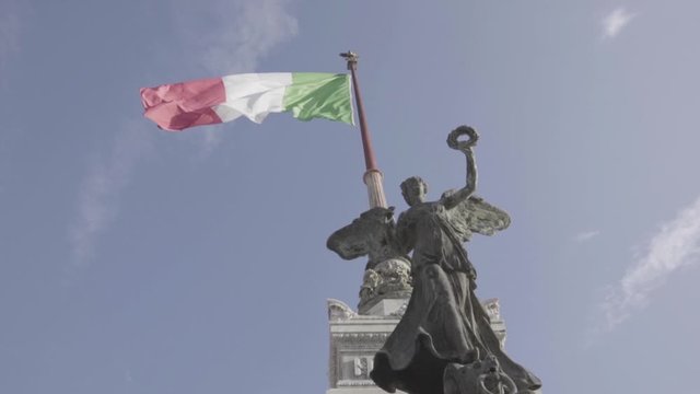 Low angle, statue holds Italian flag in Rome