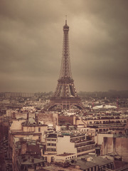 Fototapeta na wymiar Eiffel tower and rooftops, Paris, France, vintage old color photo effect, view from Arc de Triomphe.