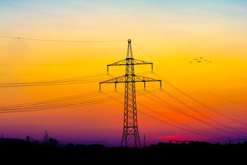 High voltage electricity pylons and transmission power lines on the blue sky background.