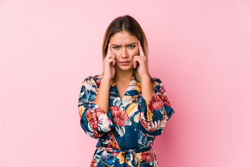 Young caucasian woman wearing pajamas focused on a task, keeping forefingers pointing head.