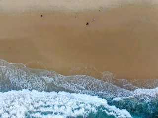 Aerial top view of the ocean colorful waves washing on the coast of the Pacific ocean. California. USA