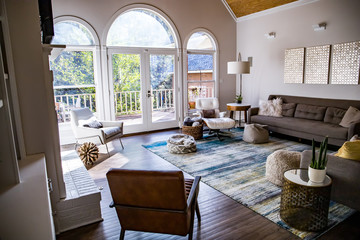 Mid century modern contemporary style living room den in a spacious open home with a vaulted ceiling and a pine wood ceiling and neutral gray couch and furniture