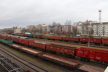 Fototapeta na wymiar Red freight cars on railroad tracks against the background of houses.