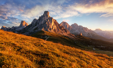 Amazing natural Landscape with colorful sky of Dolomites Alps during sunset. Passo Giau with famous...