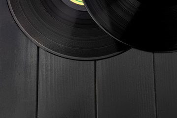 Traditional black vinyl records on gray wooden table