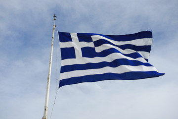 National flag of Greece on blue cloudy sky background