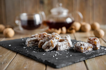 Sweet Turkish delight with nuts and raisins on a grey platter on a wooden table close-up
