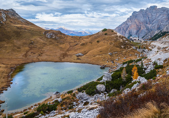 Overcast morning autumn alpine Dolomites mountain scene. Peaceful Valparola Path and Lake view, Belluno, Italy.