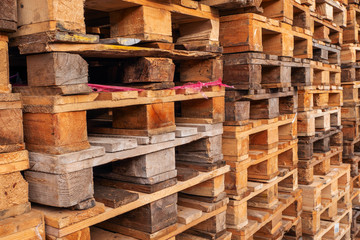 A lot stacks of used  wooden pallets of euro type on warehouse is ready for recycling. Industrial background. Close-up.