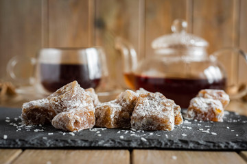 Sweet Turkish delight with nuts and raisins on a grey platter on a wooden table close-up