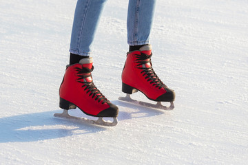 feet in red skates on an ice rink. hobbies and leisure. winter sports