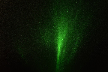 Fototapeta na wymiar Green rays, lightning and glitter on a black background