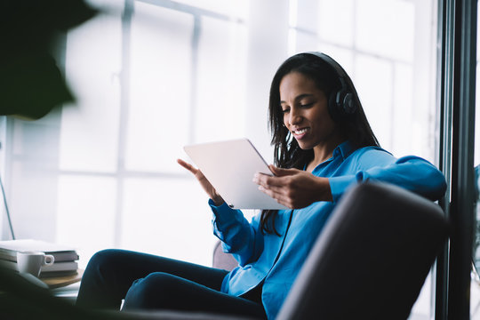 Smiling Black Lady In Headphones Touching Tablet Screen