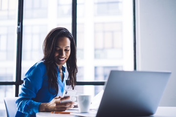 Black entrepreneur using phone in office