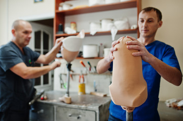 Two prosthetist man workers making prosthetic leg while working in laboratory.