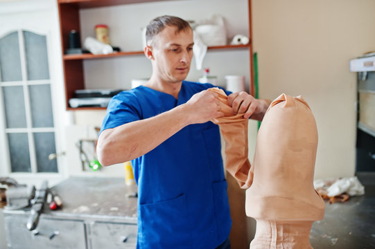Prosthetist man making prosthetic leg while working in laboratory.