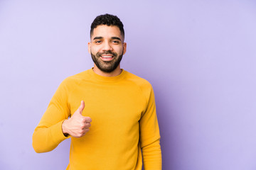 Young mixed race arabic man isolated smiling and raising thumb up