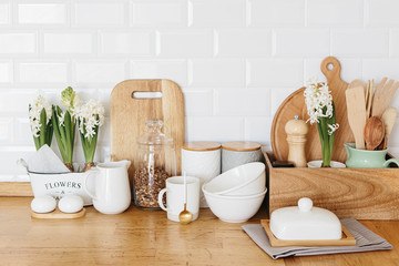 Fototapeta na wymiar Kitchen utensils and dishware spring flowers on wooden table.