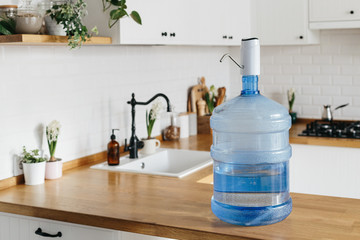 A larger bottle of clean water 19 liters with automatic white pomp in the interior of the apartment...