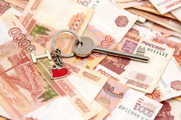 A metal key on five-thousand-ruble notes. Concept photo as a symbol of improving living conditions, buying or renting a home.