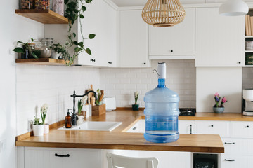 A larger bottle of clean water 19 liters with automatic white pomp in the interior of the apartment...
