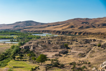 View of the landscape with an archeological site by the rock town of Uplistsikhe, Georgia on a beautiful sunny summer day