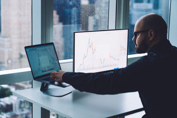 Smart man working with chart on laptop