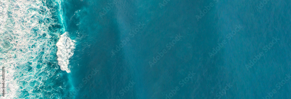 Wall mural aerial view to waves in ocean splashing waves.