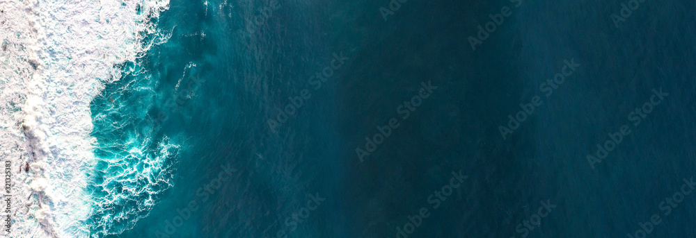 Wall mural aerial view to waves in ocean splashing waves.