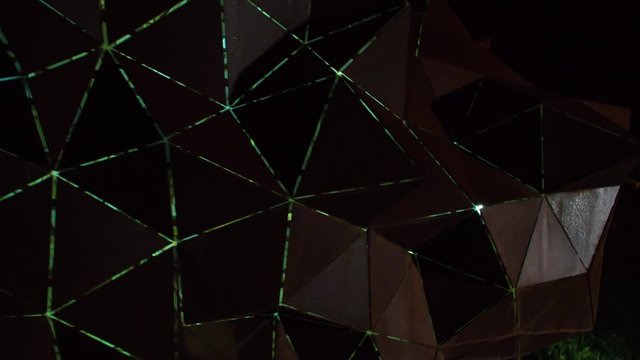 Night circle shot of illuminated famous steel sculpture Meteorite, Forma Viva Ravne, Slovenia