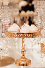 Sweet cakes on a buffet table. Delicious candy bar with cake pops. White and gold style, beautiful design.