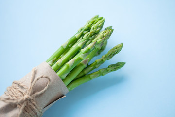 bunch of fresh green asparagus on a blue background.