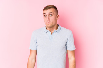 Fototapeta premium Young caucasian man isolated shrugs shoulders and open eyes confused.