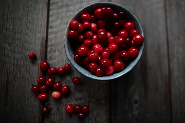fresh cranberries in a  bowl on wooden background 