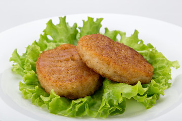 Cooked vegetarian cutlets on lettuce leaves. Fried breaded cutlet isolated on white background. freshly grilled burger vegetarian cutlets. Tasty crispy fried fresh cutlets. Juicy delicious cutlets