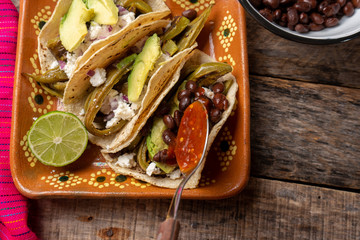 Mexican grilled nopal cactus tacos with cheese and avocado on wooden background