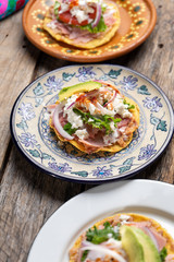 Mexican ham toast also called tostadas with beans and cheese on wooden background