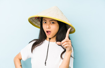 Fototapeta premium Young chinese woman wearing a vietnamese hay isolated smiling cheerful showing number five with fingers.