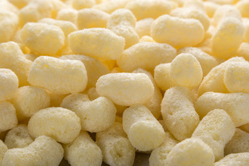 Yellow corn sticks close-up. Backgrounds and textures. Close-up shot. Delicious sweet corn sticks. A few yellow, crunchy corn snacks