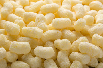 Yellow corn sticks close-up. Backgrounds and textures. Close-up shot. Delicious sweet corn sticks. A few yellow, crunchy corn snacks