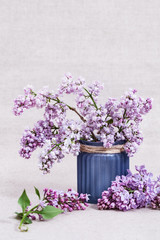 Beautiful blooming lilac.  Bouquet of lilacs in blue vase on table with copy space. Selective focus.