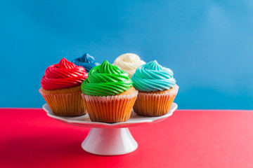 Five birthday cupcakes on a white cakestand