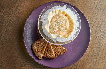 An unusual, luxury delicacy is pike caviar in a shell on ice. Wooden background. Tasty food. Film effect during post. Soft focus