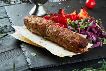 Close up view on grilled Lyulya kebab or Lule kebab. shashlik or barbecue meat. Shish kebab, traditional georgian cuisine food. Copy space for design. Grilled vegetables