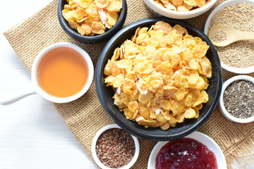 Cereal flakes without sugar, accompanied by seeds, jam and honey