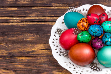 painted eggs of different colors on a wooden table, Easter decoration, Place for text