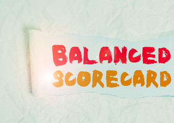 Word writing text Balanced Scorecard. Business photo showcasing a perforanalysisce metric used in strategic analysisment Cardboard which is torn in the middle placed above a plain table backdrop