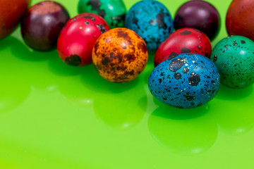 painted eggs of different colors on a green background, Easter decoration, Place for text