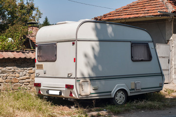 Old vintage caravan side view closeup at country house in sunny day