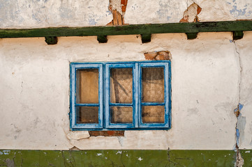 Old weathered country house blue wooden window closeup